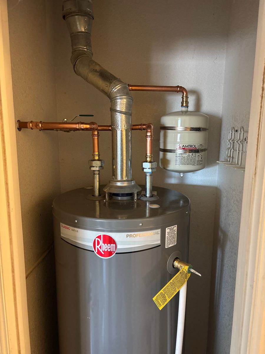 Licensed plumber installing a new residential tank water heater in a Pueblo, Colorado home